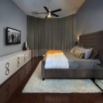 Кровать с коричневым массивным изголовьем в серой спальне